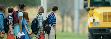 Image of students waiting for approaching school bus at bus stop 